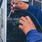 Electrician working on a circuit breaker panel.