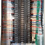 Close-up of an electrical breaker panel with labeled wires connected.