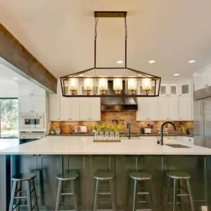 Modern kitchen with large island, hanging lights, and bar stools.