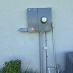 Electrical meter and panel mounted on an exterior wall.